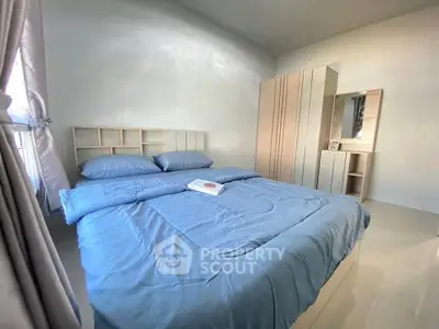 Cozy bedroom with modern furnishings and ample natural light.