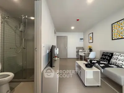 Modern living room with stylish decor and adjacent bathroom in a contemporary apartment.