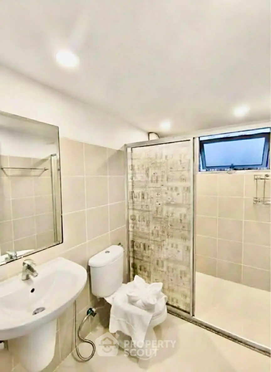 Modern bathroom with tiled walls and glass shower enclosure