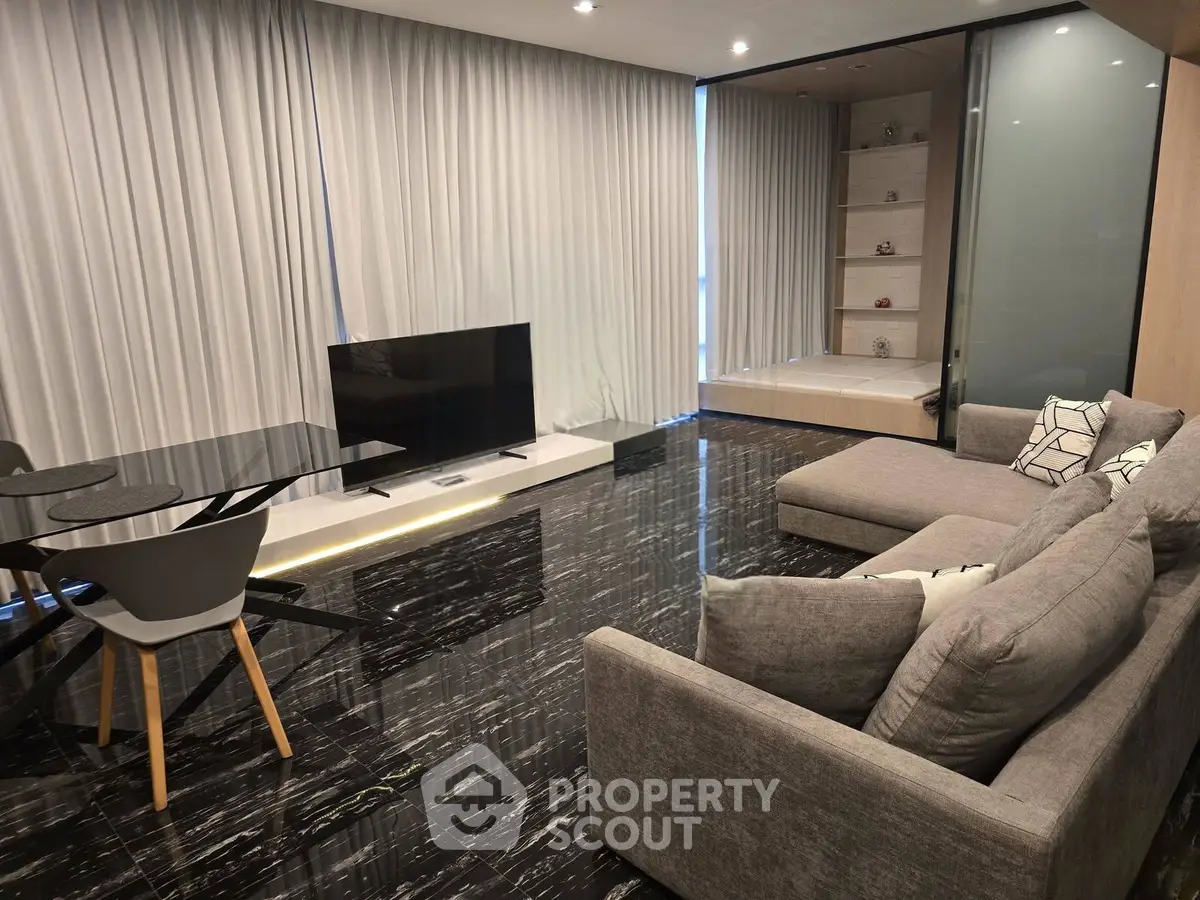 Luxurious modern living room with sleek black flooring and elegant furnishings.
