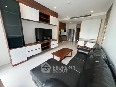Modern living room with sleek furniture and open kitchen layout in a stylish apartment.
