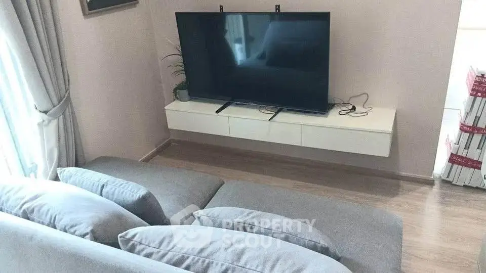 Modern living room with sleek TV setup and cozy gray sofa