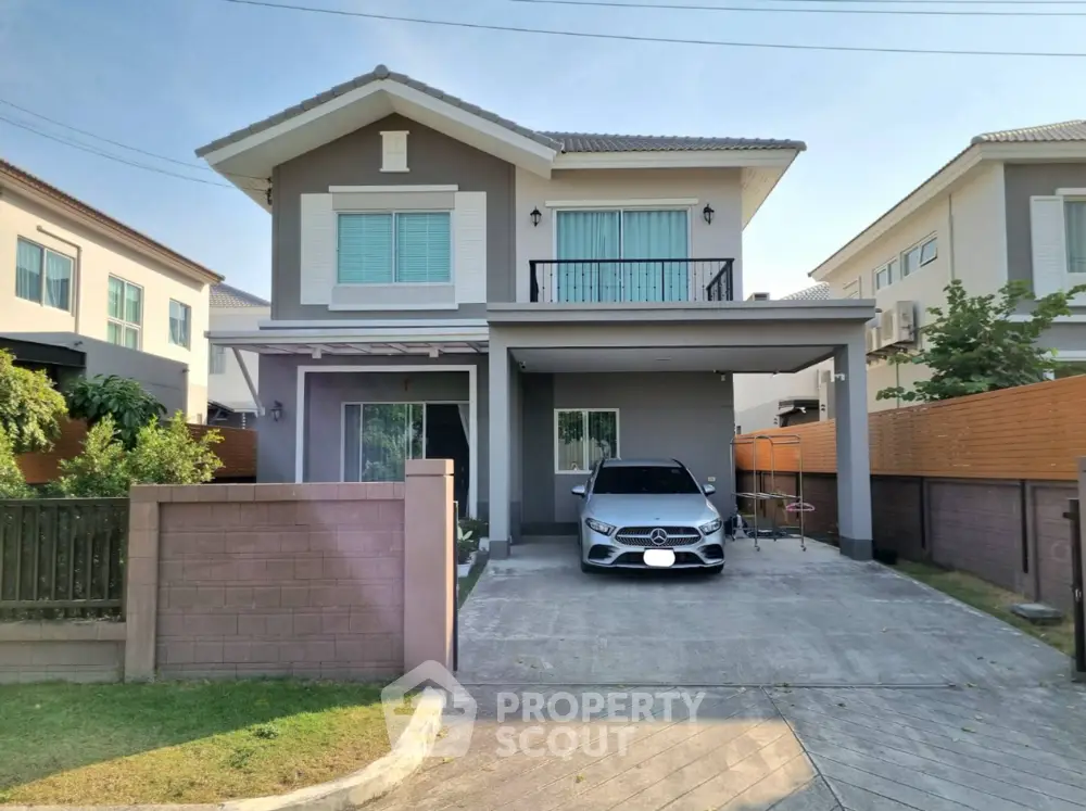 Modern two-story house with driveway and car parked, featuring a sleek contemporary design and spacious layout.