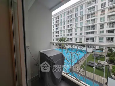 Charming balcony view overlooking a modern apartment complex with a pool, perfect for relaxation and leisure.