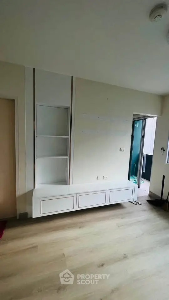 Modern minimalist living room with built-in shelving and light wood flooring