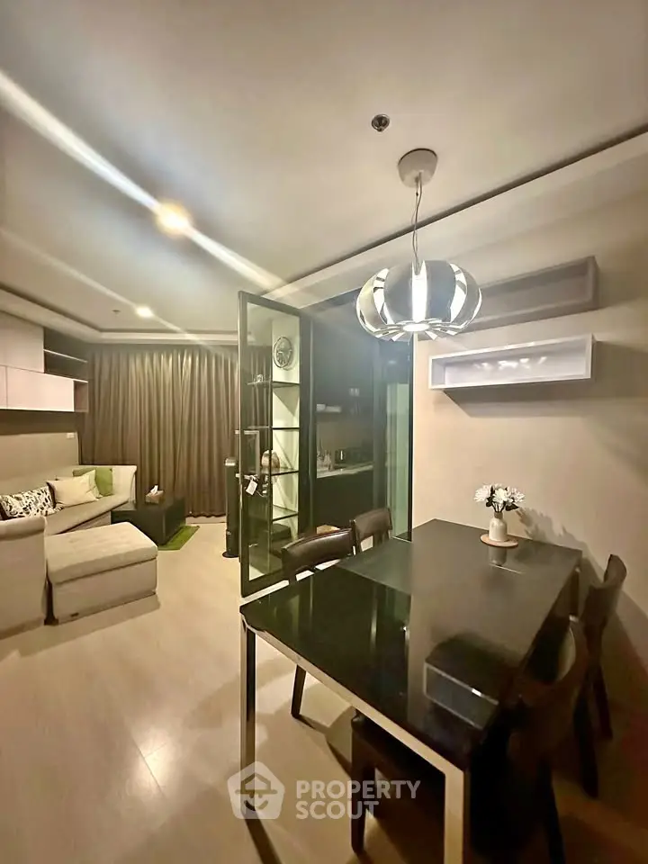 Modern living room with elegant dining area and stylish lighting in a cozy apartment.