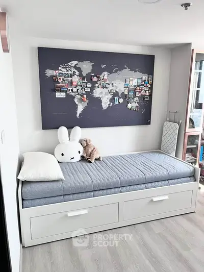 Charming bedroom with world map decor and cozy single bed, perfect for a child's room.