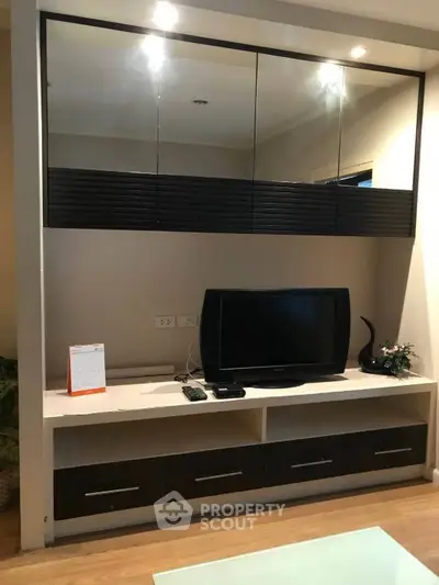 Modern living room with sleek TV stand and mirrored cabinets