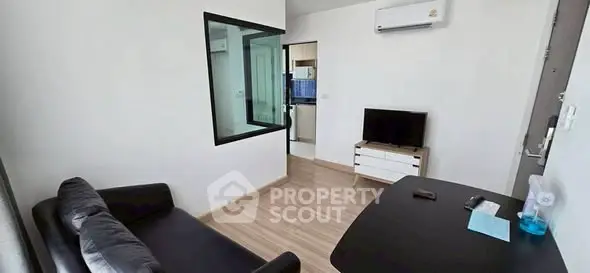 Modern living room with sleek black sofa and wall-mounted TV