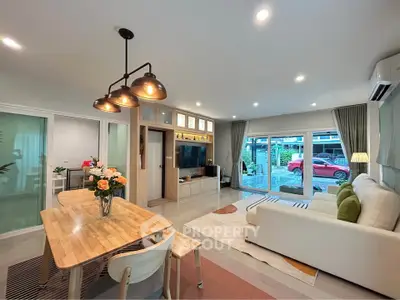 Spacious modern living room with dining area and large windows overlooking garden.