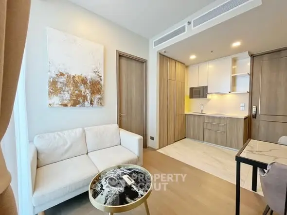 Modern living room with cozy sofa and stylish kitchen in open layout apartment.