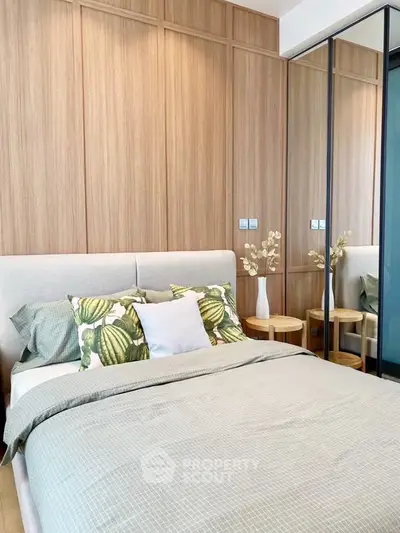 Modern bedroom with stylish decor and mirrored wardrobe doors, featuring elegant wood paneling.