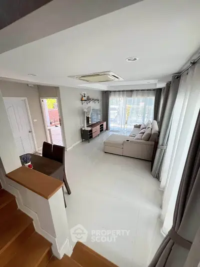 Spacious living room with modern decor and large windows offering natural light.