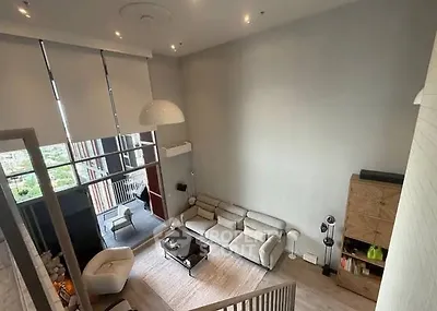 Spacious modern living room with high ceiling and large windows offering stunning views.