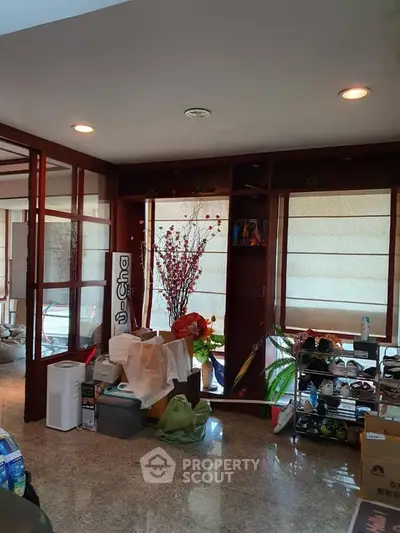 Spacious interior with natural light and modern decor, featuring large windows and stylish furnishings.