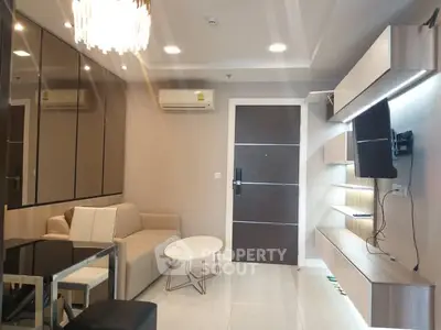 Modern living room with sleek furniture and wall-mounted TV in a stylish apartment.