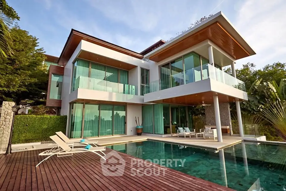 Luxurious modern villa with pool and spacious outdoor deck, featuring floor-to-ceiling windows and sleek architectural design.