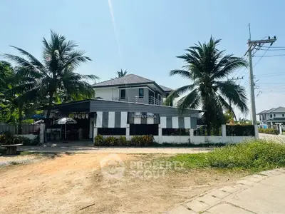 Charming two-story house with lush palm trees and spacious front yard