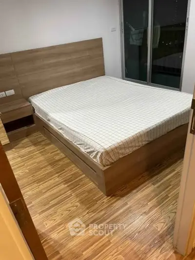 Modern bedroom with wooden flooring and large bed, featuring a sleek design and cozy ambiance.