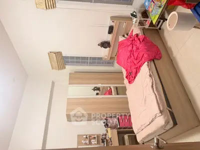 Cozy bedroom with modern wooden furniture and vibrant pink bedding.