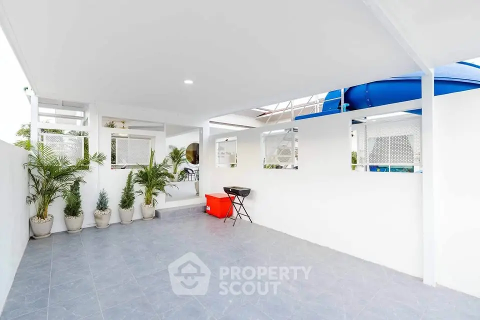 Spacious outdoor patio with modern design and potted plants, perfect for relaxation and entertainment.