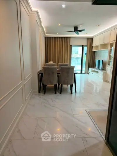 Elegant living room with marble flooring, modern dining set, and large window offering natural light.