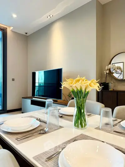 Elegant dining area with modern decor and TV in a stylish apartment