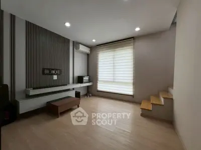 Modern minimalist living room with wooden flooring and staircase