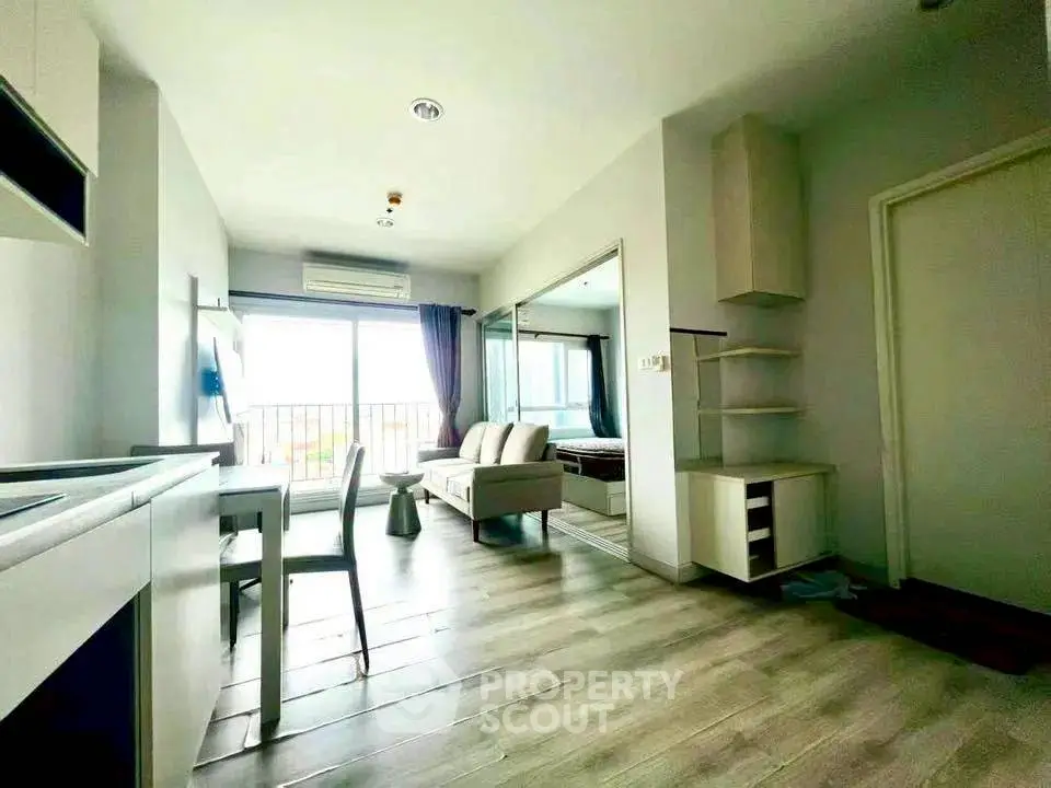 Modern open-plan living room with sleek furniture and large windows in a stylish apartment.