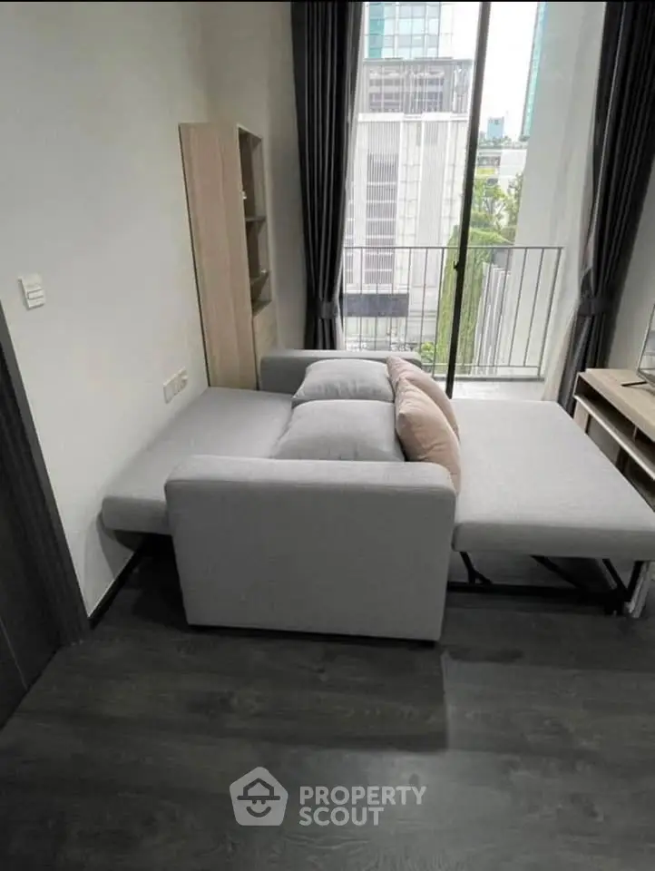 Modern living room with sofa bed and city view from balcony