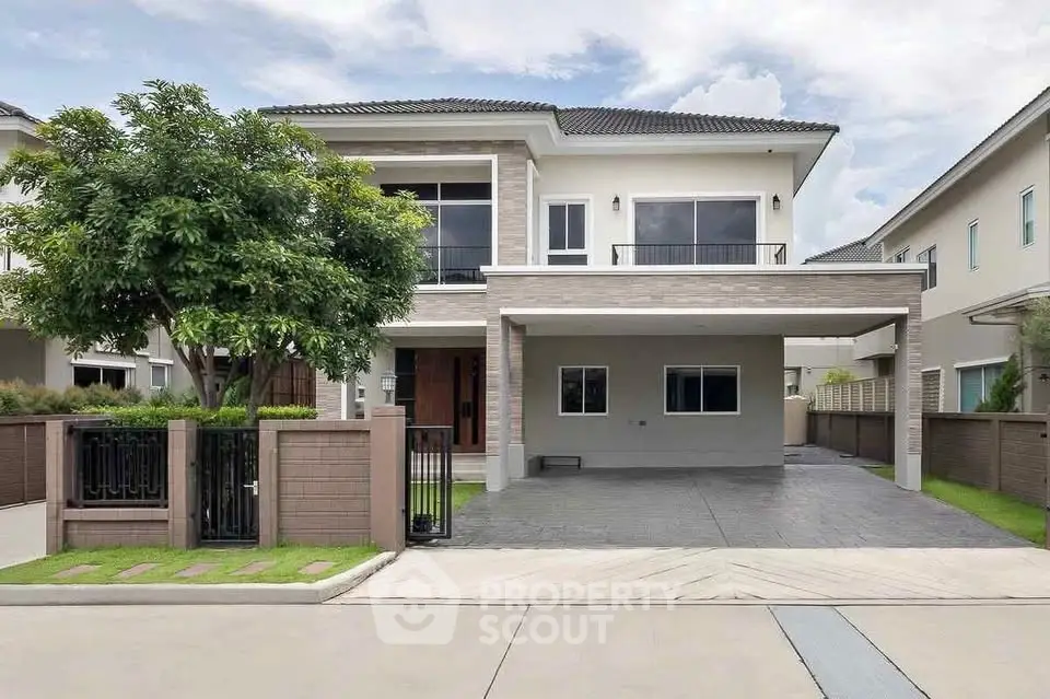 Modern two-story house with spacious driveway and lush greenery in a serene neighborhood.