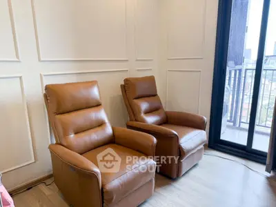 Cozy living room with two plush leather recliners and a balcony view