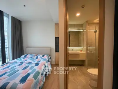 Modern bedroom with ensuite bathroom featuring stylish decor and large windows.