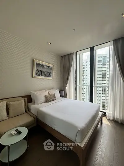 Modern bedroom with large windows and city view, featuring elegant decor and cozy ambiance.