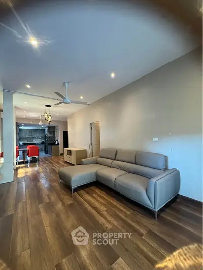 Spacious modern living room with elegant wooden flooring and stylish furniture