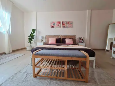 Spacious bedroom with stylish decor and natural light, featuring a cozy bed and elegant furnishings.