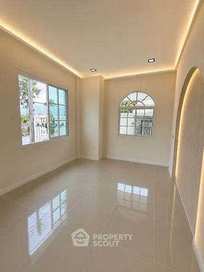 Spacious modern living room with large windows and elegant lighting