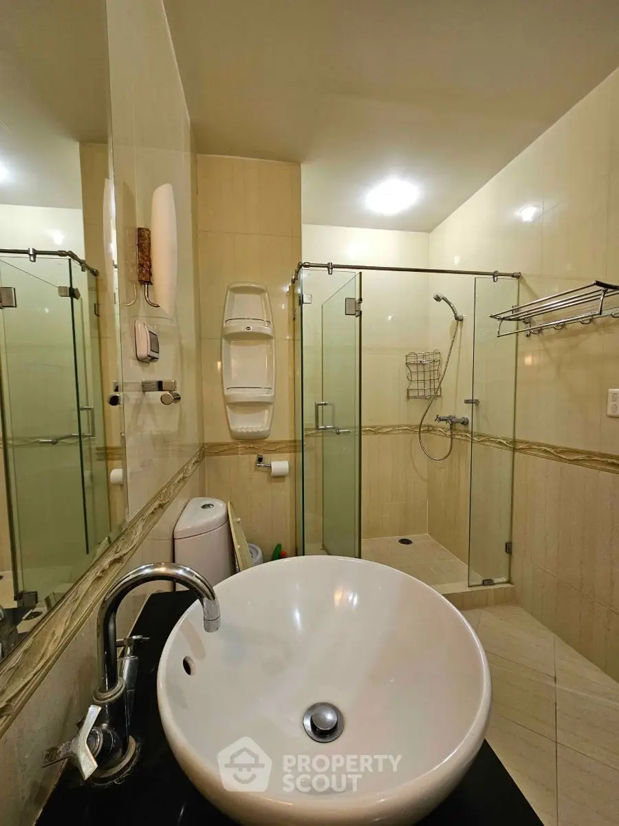 Modern bathroom with glass shower and stylish sink in elegant home.