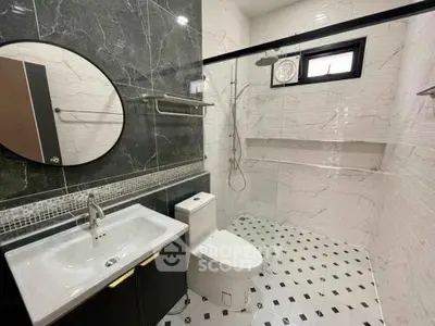 Modern bathroom with sleek black and white design, featuring a spacious shower area.