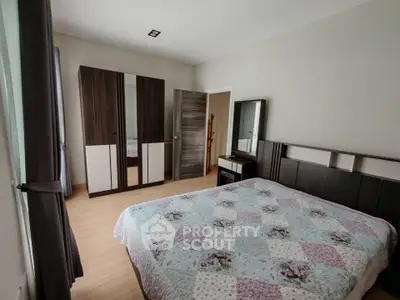 Spacious bedroom with elegant wooden furniture and cozy quilted bedspread.