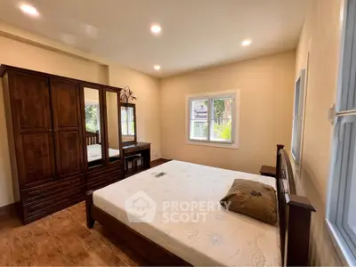 Spacious bedroom with wooden furniture and large windows for natural light