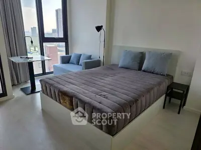 Modern bedroom with city view, featuring a cozy bed and stylish decor in a high-rise apartment.