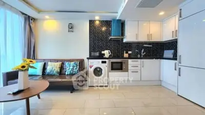 Modern open-plan living room with sleek kitchen and washing machine