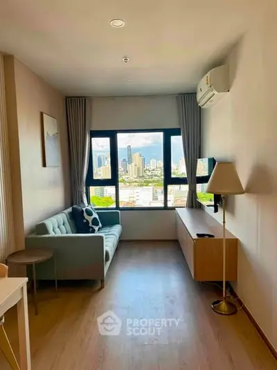 Modern living room with city view, featuring a cozy sofa and stylish decor in a high-rise apartment.