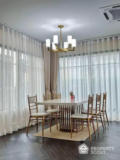 Elegant dining area with modern chandelier and floor-to-ceiling windows