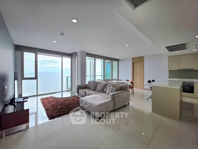 Spacious modern living room with ocean view, open kitchen, and elegant furnishings in a luxury apartment.