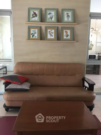 Cozy living room with stylish sofa and floral artwork, perfect for relaxation and modern living.