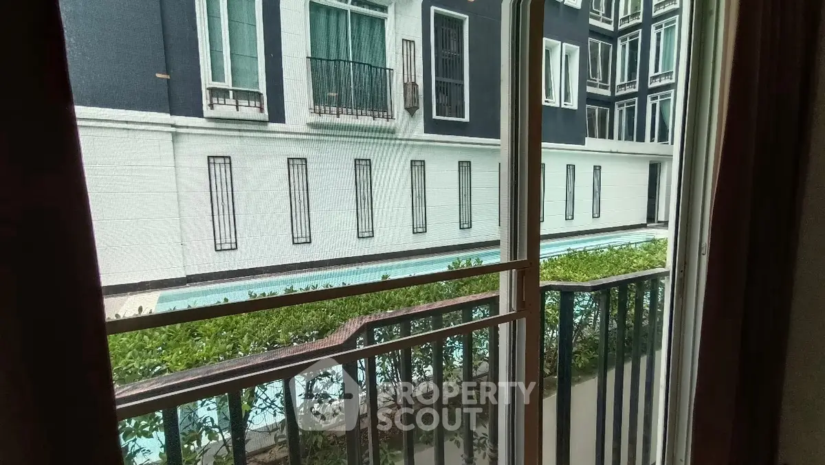 View of modern apartment building with pool from balcony.