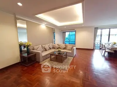 Spacious living room with elegant parquet flooring and cozy sectional sofa in a modern apartment.