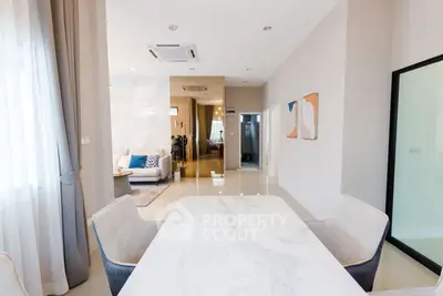 Modern open-plan living and dining area with elegant decor and natural light.